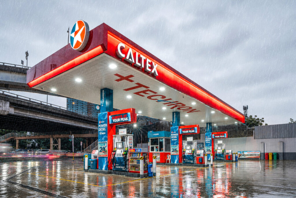 A Caltex station with Techron branding in the Philippines, operating during a rainy day to help motorists prevent water contamination in fuel tanks.