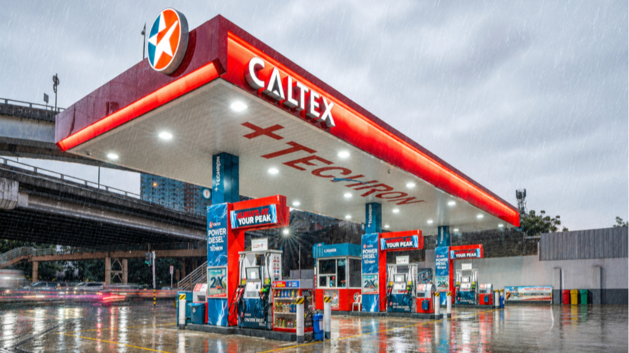 Rain falls on the canopy and wet pavement of a Caltex Philippines station, highlighting vehicle maintenance checks and fuels designed to keep water out of your fuel tank.