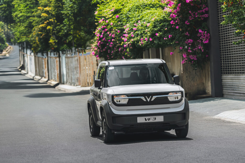 VinFast VF 3 white mini electric SUV driving on a Philippine street, representing VinFast’s expansion and its 10-year warranty reliability initiative in the Philippines.