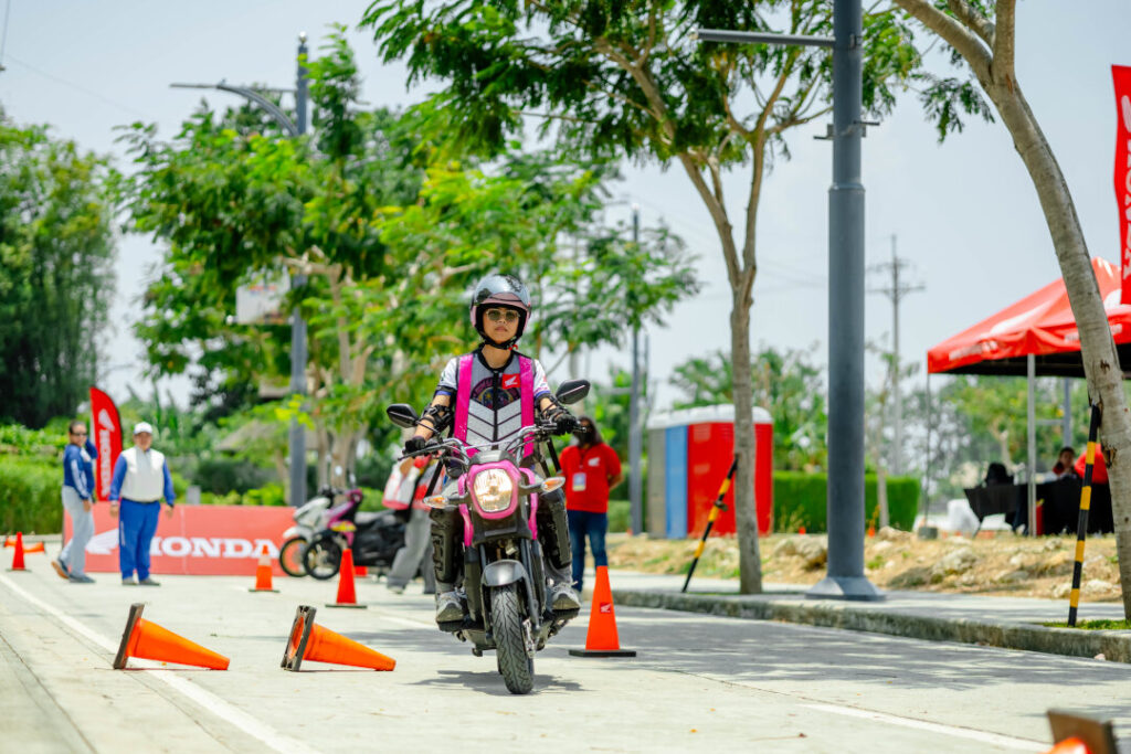 A female motorcyclist wearing proper safety gear and a high-vis vest navigates a skills course during the Honda Riders Convention Visayas.