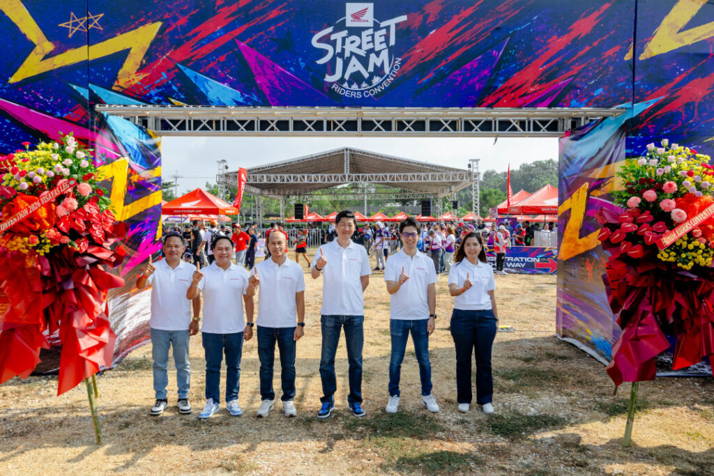 Honda Philippines executives in white polo shirts gather at the entrance of the Honda Riders Convention Visayas, pointing upward in a gesture of success.