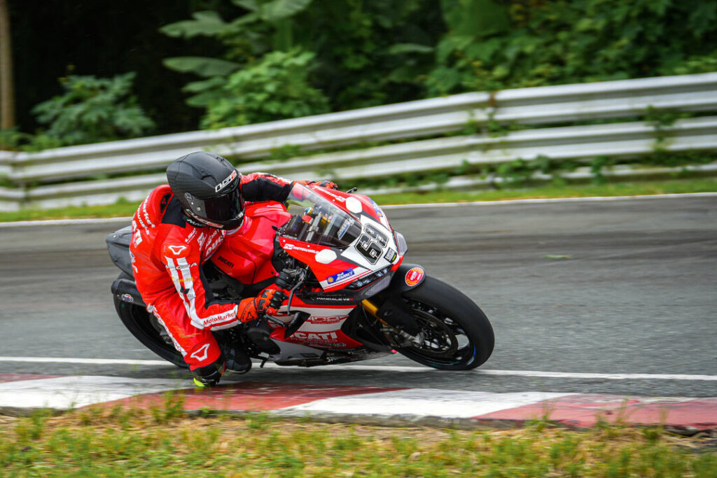 Action shot of a Ducati rider wearing a black helmet and red leathers cornering at the 2026 Philippine Superbike Championship in Batangas.