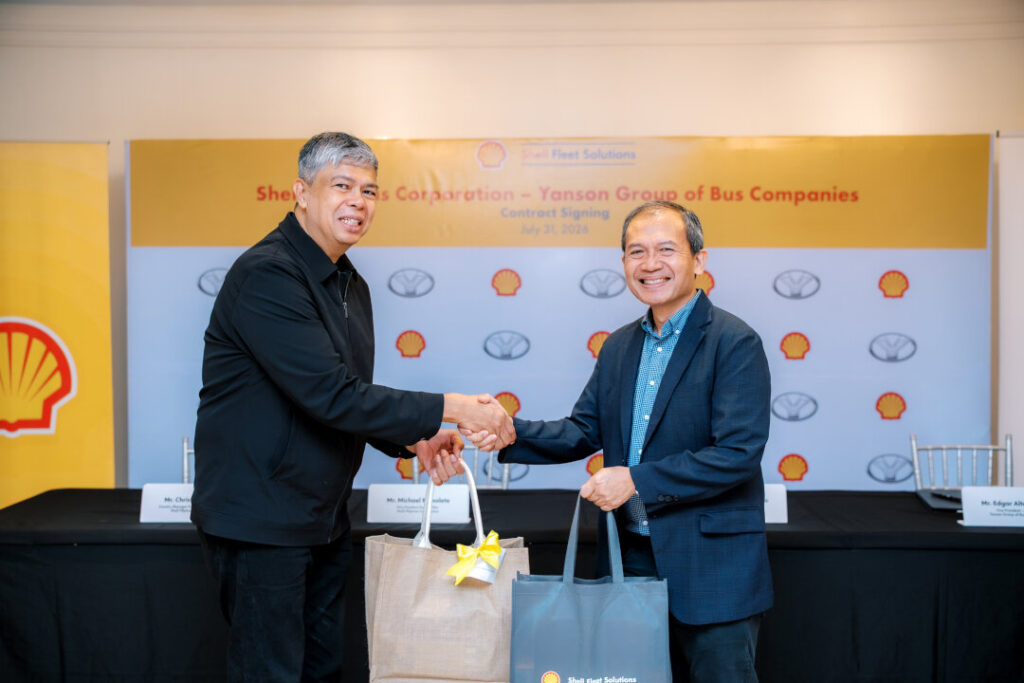 Michael Ramolete of Shell Pilipinas (right) and Dr. Hernan B. Omecillo of Yanson Group (left) shake hands, holding gift bags, after renewing the Shell Pilipinas Yanson Group fuel agreement.