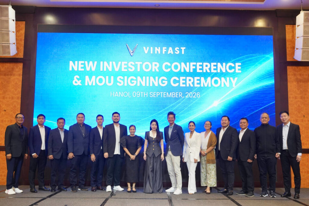 Key executives and partners from 13 local dealerships gather on stage for a group photograph at the VinFast New Investor Conference & MOU Signing Ceremony in Hanoi, finalizing agreements to develop 27 new VinFast EV showrooms Philippines.