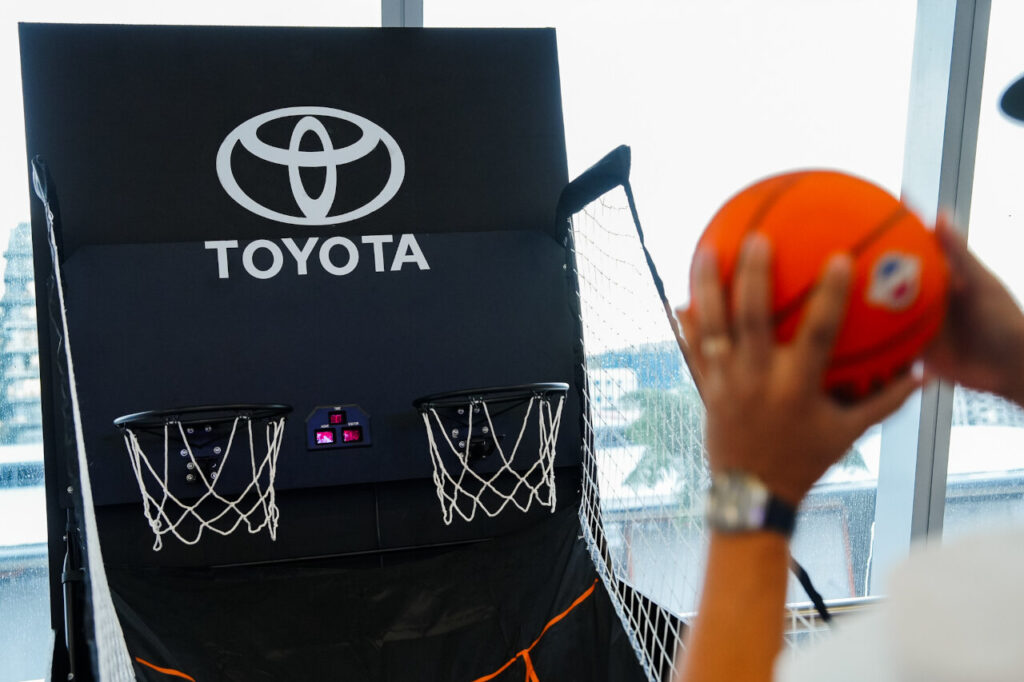 A fan participating in the interactive Toyota Challenge Zone at the Toyota PH B.LEAGUE Manila Games, trying to score a basket on the custom-branded indoor hoop.