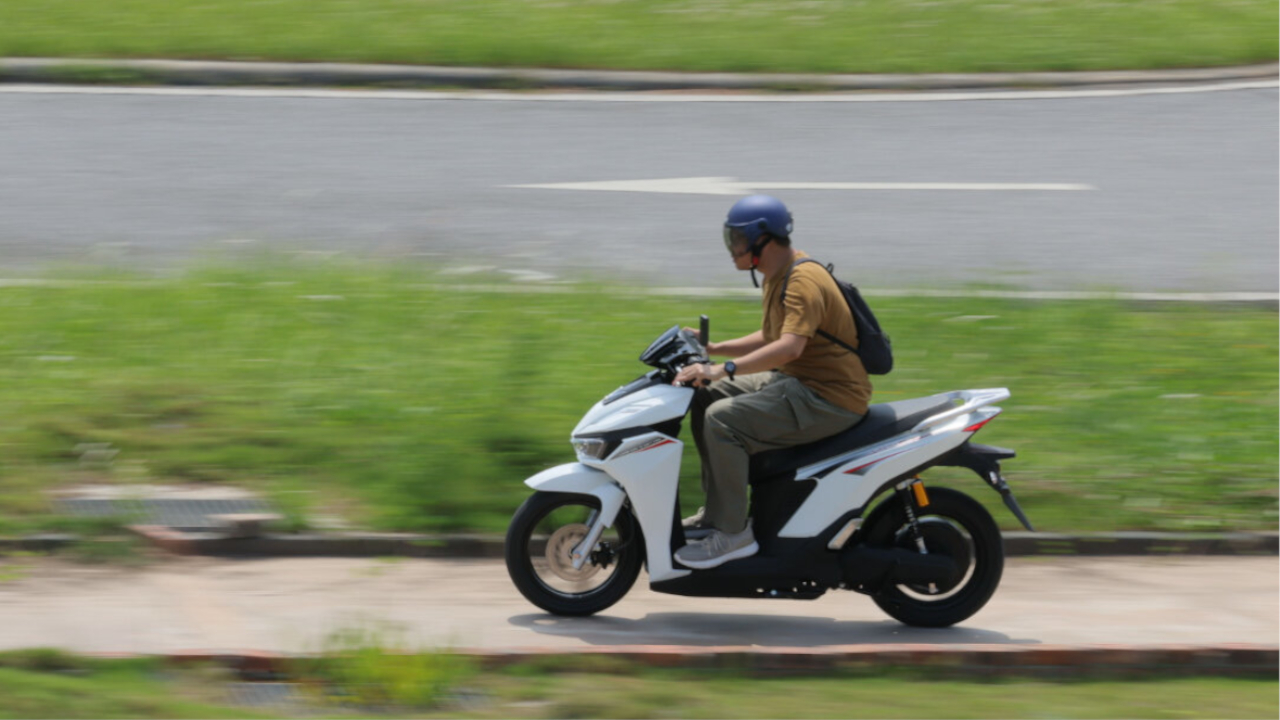 Commuter riding VinFast E-Motorcycles electric scooter in motion outdoors