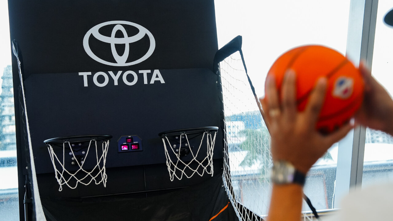 Close up of A fan participating in the interactive Toyota Challenge Zone at the Toyota PH B.LEAGUE Manila Games, trying to score a basket on the custom-branded indoor hoop.